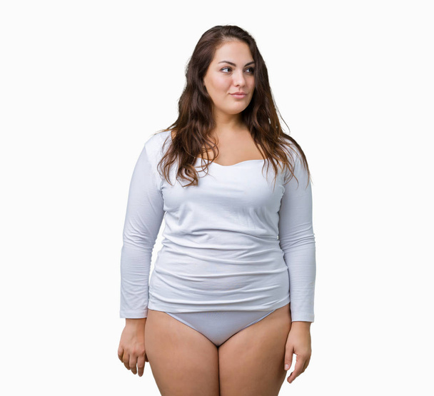 Beautiful plus size young overwight woman wearing white underwear over isolated background smiling looking side and staring away thinking. - Valokuva, kuva