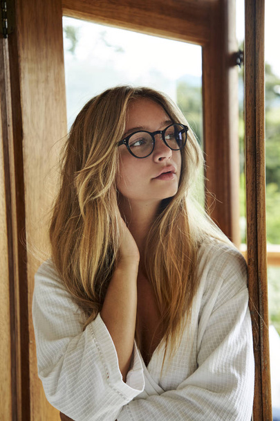 Pretty young woman in glasses and robe, looking away - Valokuva, kuva