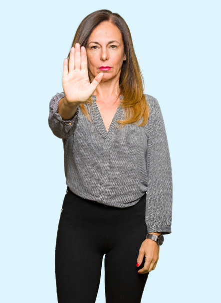 Mulher de negócios de meia-idade bonita fazendo parar de cantar com palma da mão. Expressão de alerta com gesto negativo e grave no rosto
. - Foto, Imagem