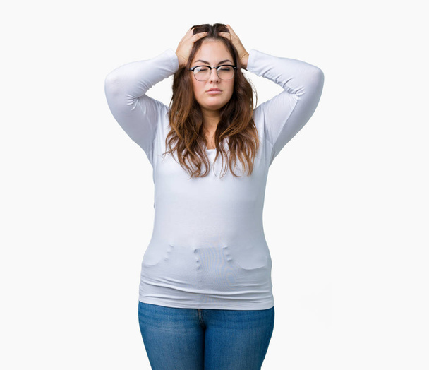 Beautiful plus size young woman over isolated background suffering from headache desperate and stressed because pain and migraine. Hands on head. - Photo, image