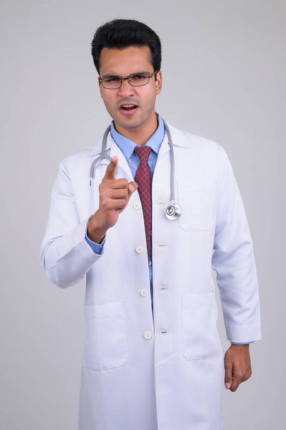 Portrait of angry young Indian man doctor pointing at camera - Photo, Image