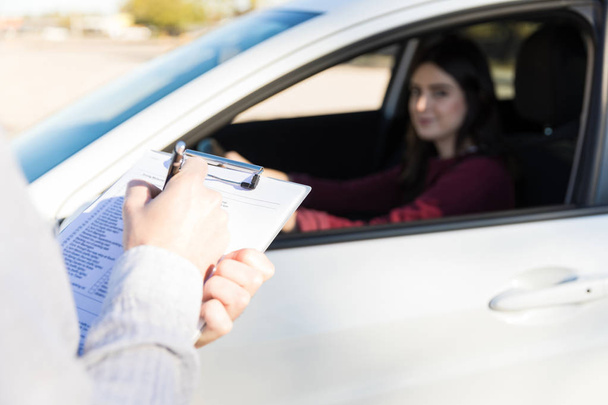 Cropped image of male trainer giving marks for driving test - Photo, image
