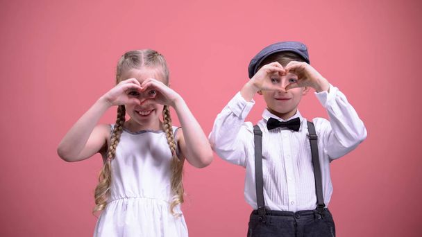 Cute smiling children making hearts with their hands, celebrating Valentines day - Photo, Image