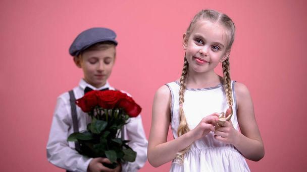 Romantic boy ready to present bouquet of red roses to little lady Valentines day - Foto, immagini