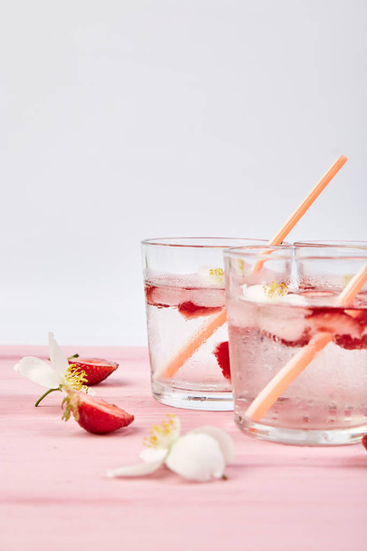 Strawberry detox water with jasmine flower. Summer iced drink or tea. Lemonade with berry. Flavored Water in glasses with Fresh Strawberry. Diet. - Foto, afbeelding