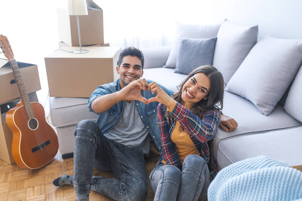 Young couple showing love sign in new home  - Foto, Bild
