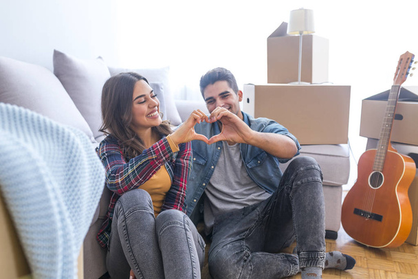 Young couple showing love sign in new home  - Foto, Imagem