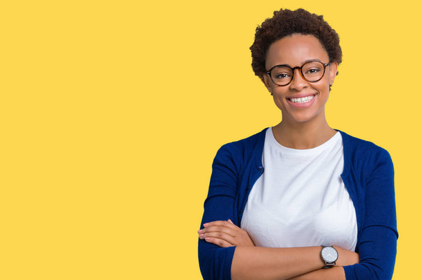 Young beautiful african american woman wearing glasses over isolated background happy face smiling with crossed arms looking at the camera. Positive person. - Photo, Image