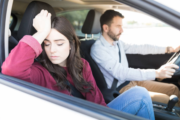 Surullinen houkutteleva nuori nainen istuu autossa poikaystävän kanssa pitkän ajomatkan aikana
 - Valokuva, kuva