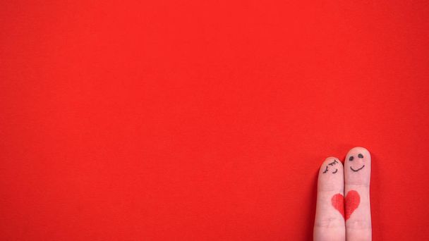 Finger face pari maalattu sydän halaus punaisella taustalla, yhdessä
 - Valokuva, kuva