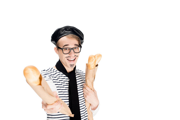 pohledný francouzský muž v brýlích s úsměvem podržíte bagety izolované na bílém  - Fotografie, Obrázek
