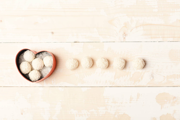 Red heart shaped box with sweets, coconut balls, top view. - Foto, imagen
