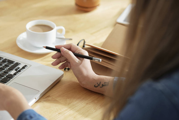 Kreatív igazgató ceruzával a kezében dolgozik laptop - Fotó, kép