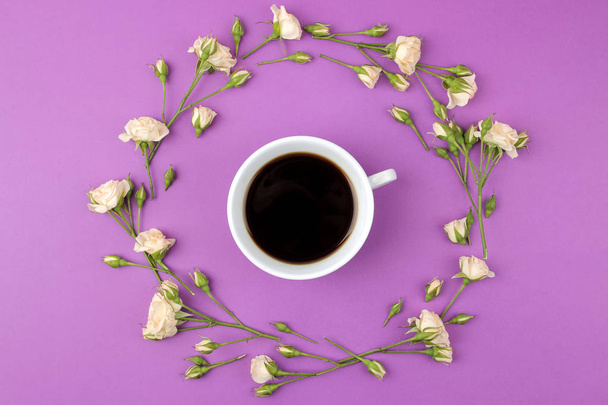 Beautiful mini roses and a cup of coffee on a bright lilac background. holidays. Valentine's Day. women's Day. top view. - Foto, imagen