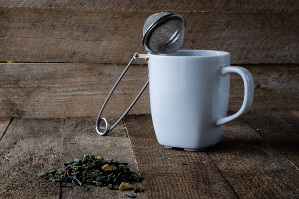 Hot tea and a mug on a wooden kitchen table - Fotoğraf, Görsel