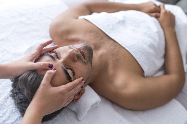 Masseur doing head massage at man in spa salon - Foto, Imagem