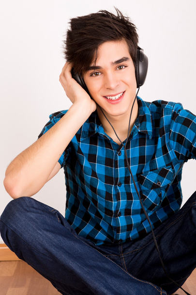 Fiatal ember hallgat zenét a fejhallgatóval otthon - Fotó, kép