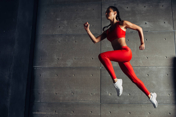 Jeune femme en forme sautant tout en courant Fitness sport fille exercice
. - Photo, image