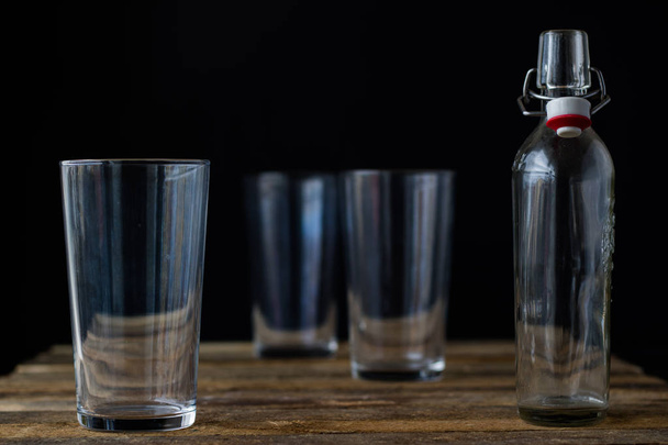 Glass dishes on a wooden table. Black background. - Valokuva, kuva