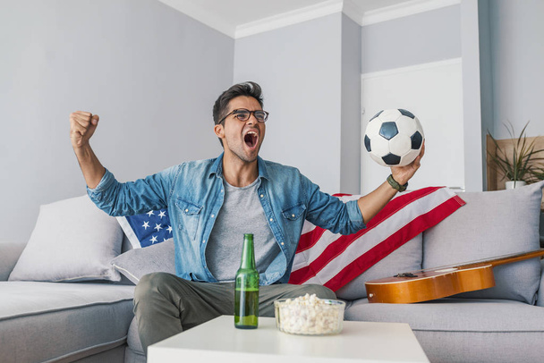 Portrait of man watching football at home - Foto, Bild