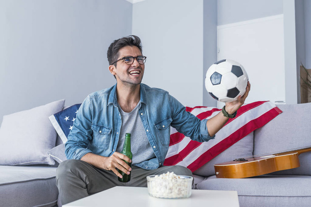 Portrait of man watching football at home - 写真・画像