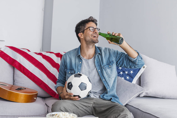 Portrait of man watching football at home - Foto, afbeelding