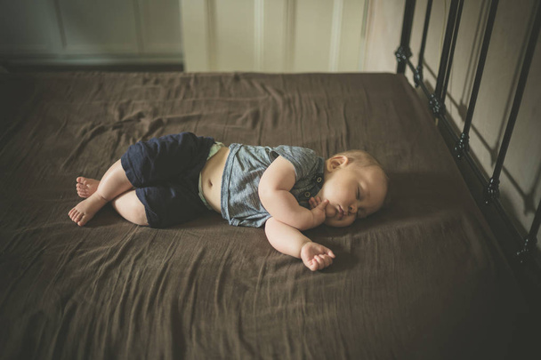 A little baby is sleeping on a bed - Foto, afbeelding