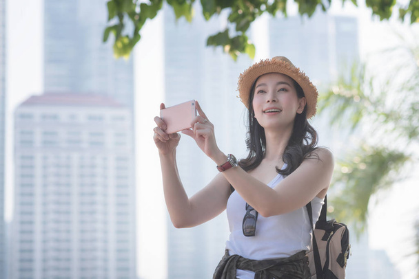 Πανέμορφο Ασίας τουριστικοί Μεμονωμένοι γυναίκα απολαύσετε τη λήψη φωτογραφιών από έξυπνο τηλέφωνο σε τουριστικά αξιοθέατα. Ταξίδια-διακοπές το καλοκαίρι - Φωτογραφία, εικόνα