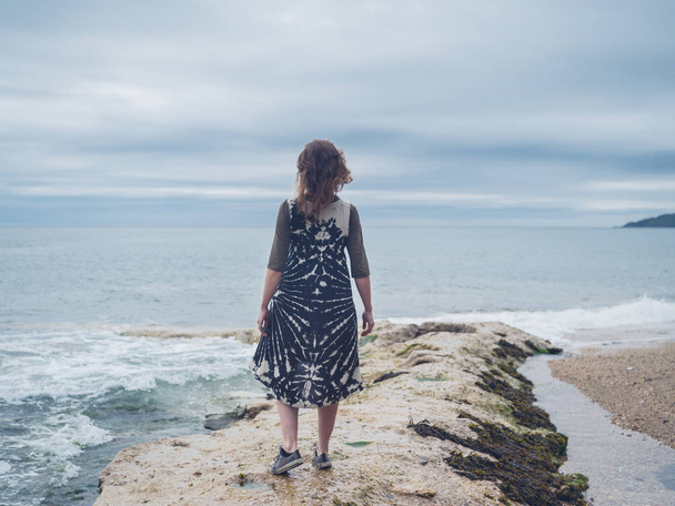 A young woman is standing by the sea - Photo, Image