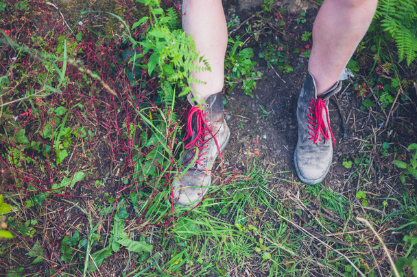 Les jambes d'une jeune femme portant des bottes de randonnée dehors dans la nature
 - Photo, image