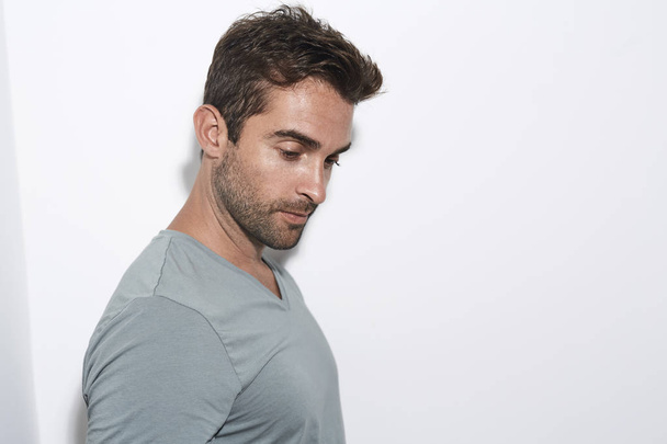 Seriously handsome guy in grey, looking down - Foto, immagini
