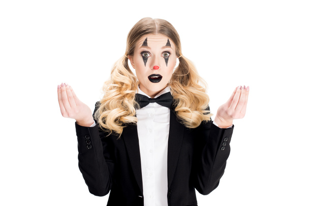 surprised female clown standing in suit and gesturing isolated on white  - 写真・画像