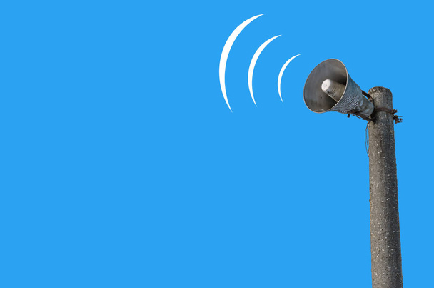 Outdoor loudspeaker on  pole against the background of blue sky, sound waves. - Photo, Image