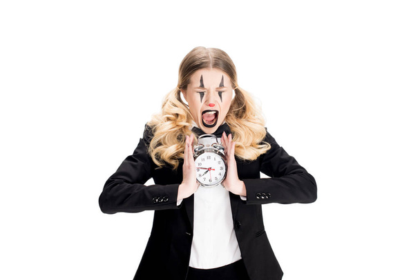 female clown holding alarm clock and screaming isolated on white  - Valokuva, kuva