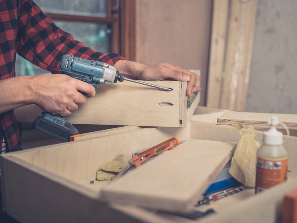 A carpenter is building a drawer in his workshop - Foto, imagen