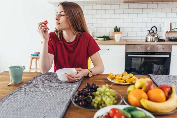 Vrouw in huis eten fruit en groenten bovenaanzicht. - Foto, afbeelding