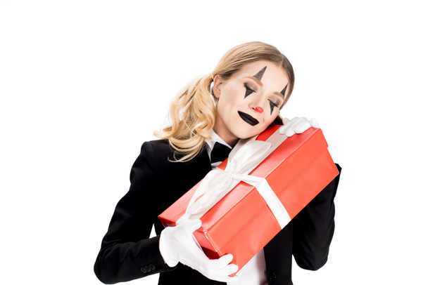 excited female clown embracing gift box isolated on white  - 写真・画像