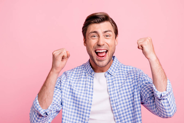 Close-up portrait of nice crazy attractive handsome cheerful cheery positive guy wearing checked shirt best luck holding fists isolated over pink pastel background - Fotoğraf, Görsel