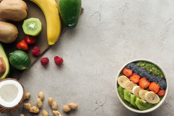 felülnézete a szürke háttér smoothie tál friss gyümölcsök és diófélék - Fotó, kép