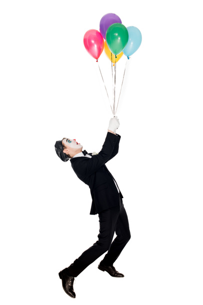 клоун в костюмі і чорний берет, дивлячись на гелієві кульки ізольовані на білому
  - Фото, зображення