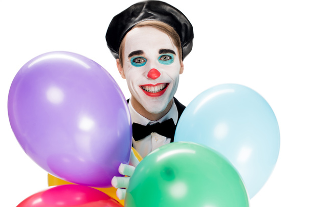 gai clown en béret noir tenant des ballons et souriant isolé sur blanc
  - Photo, image