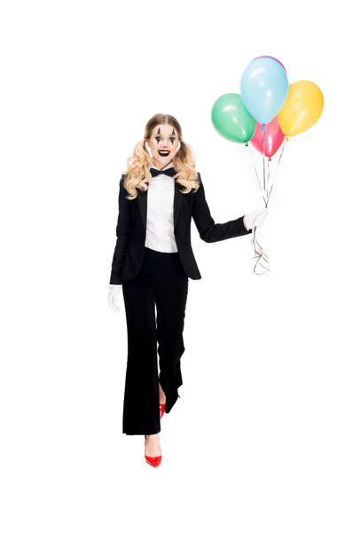 szczęśliwy clown kobiece w garniturze gospodarstwa balony i uśmiecha się na białym tle  - Zdjęcie, obraz