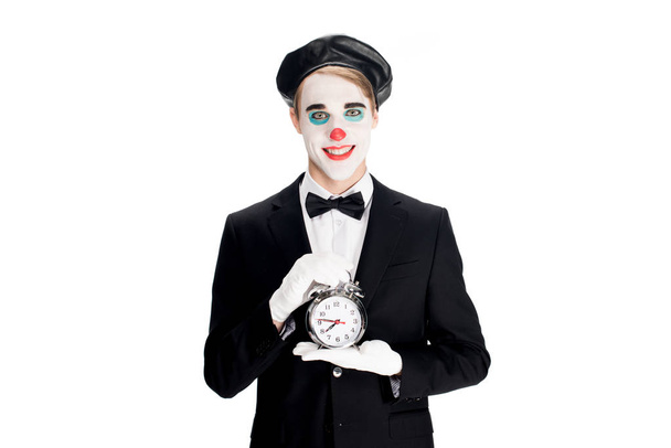 happy clown holding alarm clock in hands isolated on white  - Zdjęcie, obraz