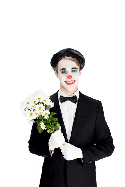 fröhlicher Clown mit Blumenstrauß in den Händen, isoliert auf weißem Grund  - Foto, Bild