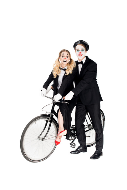 sonriente pareja de payasos montar en bicicleta aislado en blanco
  - Foto, imagen