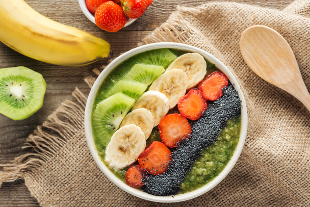 top view of fresh smoothie bowl with ingredients on sackcloth - Foto, Imagem