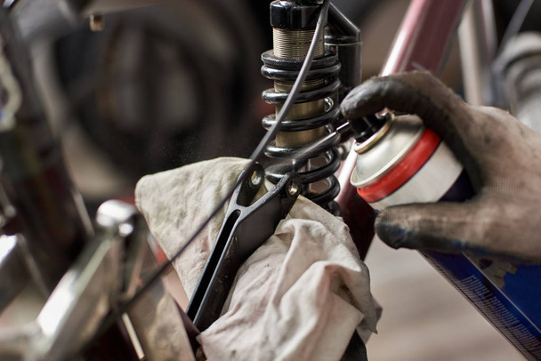 primer plano del hombre mecánico que trabaja en el taller de reparación de bicicletas, con guantes de protección
 - Foto, Imagen