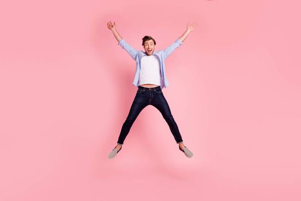 Full length body size photo of jumping high crazy cheer he his him handsome happy glad really need celebrating friday night wearing casual jeans checkered plaid shirt isolated on rose background - Foto, Imagem