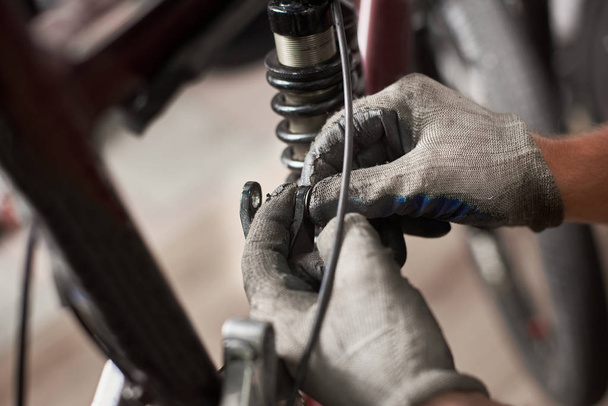 adam mekanik bisiklet tamircisi, koruyucu eldiven giymiş çalışma yakın çekim - Fotoğraf, Görsel