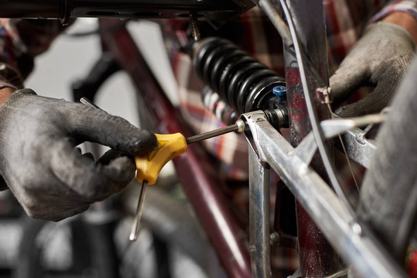 gros plan de l'homme mécanicien travaillant dans un atelier de réparation de vélos, portant des gants de protection
 - Photo, image
